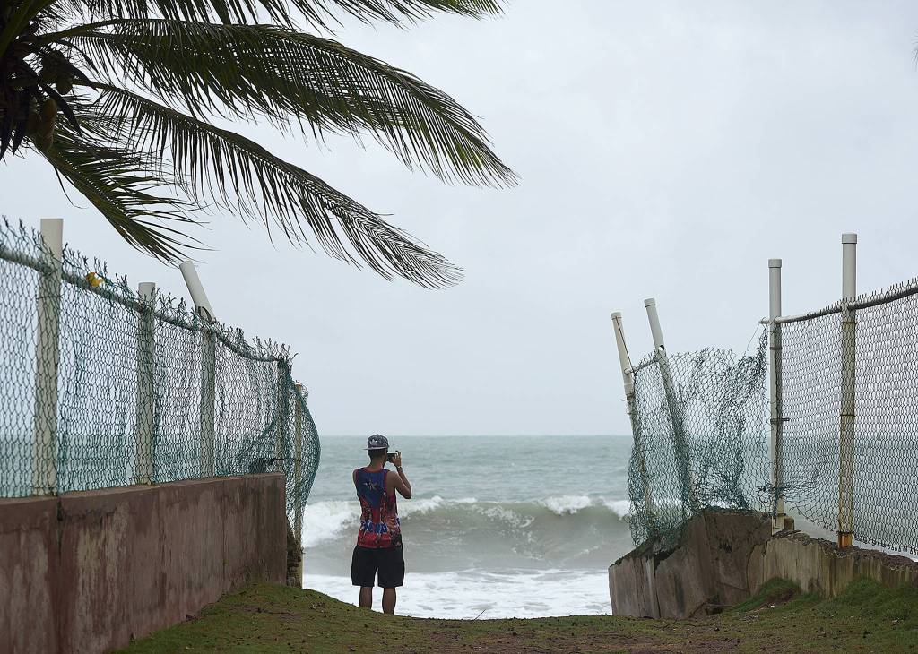 A man photographs the ocean before the arrival of Hurricane Irma in luquillo, Puerto Rico, on Wednesday. Irma roared into the Caribbean with record force early Wednesday, its 185-mph winds shaking homes and flooding buildings on a chain of small islands along a path toward Puerto Rico, Cuba and Hispaniola and a possible direct hit on densely populated South Florida. (AP Photo/Carlos Giusti)