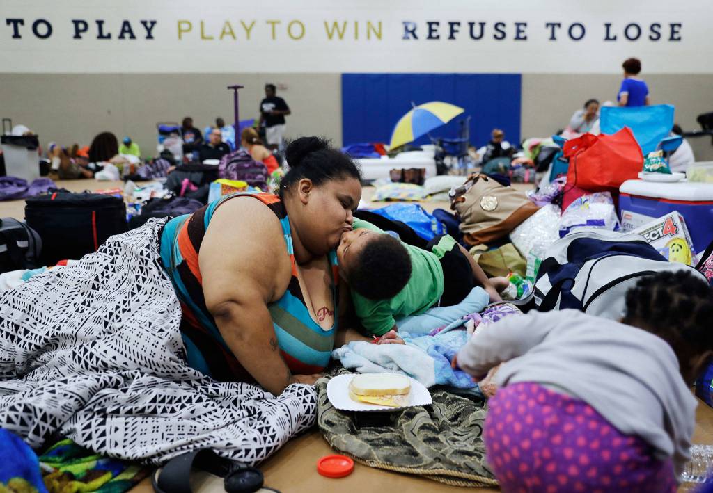 Annette Davis kisses her son Darius, 3, while staying at a shelter in Miami after evacuating from their home in Florida City, Fla., ahead of Hurricane Irma Saturday, Sept. 9, 2017. (AP Photo/David Goldman)