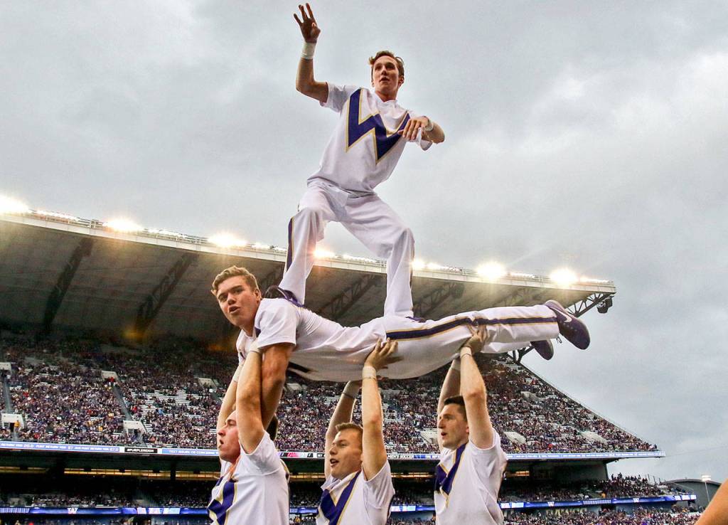Members of the Huskies cheer squad body surf Saturday night at Husky Stadium in Seattle on September 9, 2017. Washington defeated Montana 63-7. (Kevin Clark / The Herald)