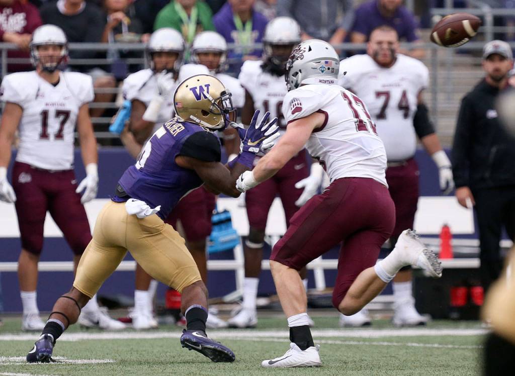 Washington&rsquo;s Chico McClatcher back tracks for a reception with Montana&rsquo;s Josh Sandry Saturday night at Husky Stadium in Seattle on September 9, 2017. Washington defeated Montana 63-7. (Kevin Clark / The Herald)