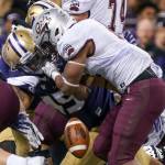 Washington&rsquo;s Jusstis Warren forces a fumble by Montana&rsquo;s Jeremy Calhoun Saturday night at Husky Stadium in Seattle on September 9, 2017. Washington defeated Montana 63-7. (Kevin Clark / The Herald)
