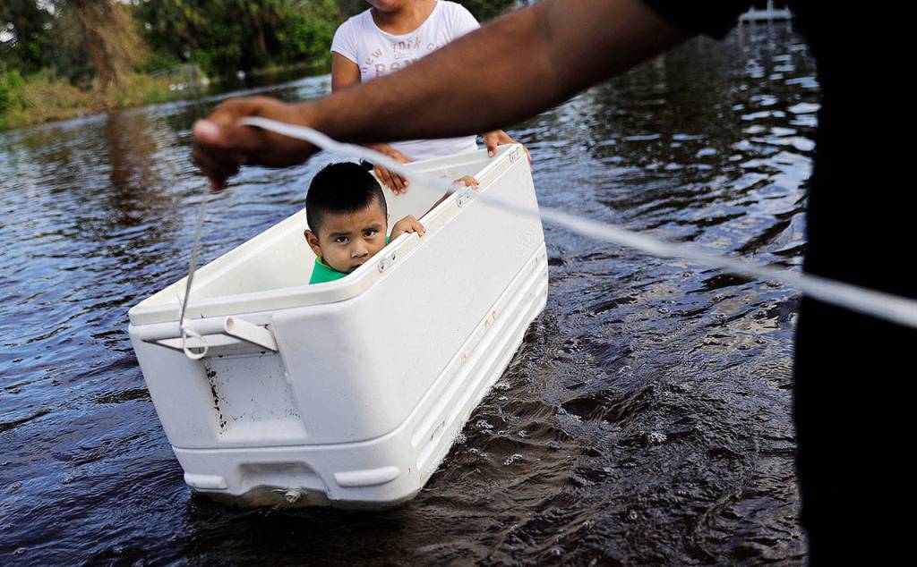 Alfonso Jose Jr., 2, is floated down his flooded street by his parents on Tuesday as they wade through water left by Hurricane Irma in Bonita Springs, Florida. (AP Photo/David Goldman)