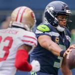 Seahawks quarterback Russell Wilson reaches for additional yardage with 49ers cornerback Rashard Robinson closing in during Sunday&rsquo;s game at CenturyLink Field in Seattle. (Kevin Clark / The Herald)