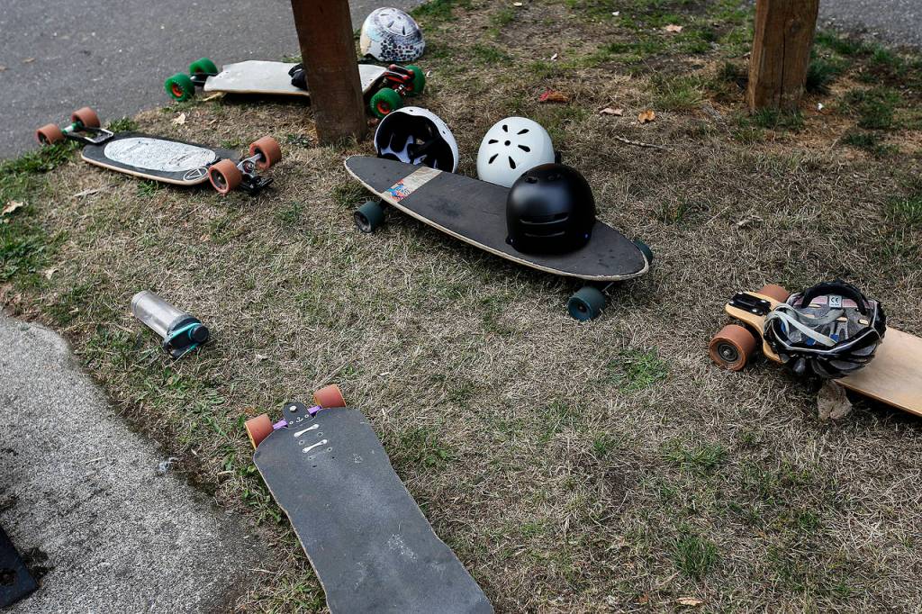 Longboards lay across a grassy strip following an 8.5 mile race in Arlington on Saturday, Sept. 23 as part of the Centennial Sk8 Festival. (Ian Terry / The Herald)