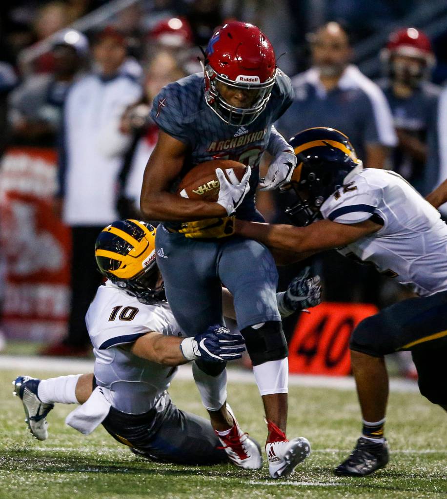 Archbishop Murphys Rwehabura Munyagi (center) is brought down by Bellevue defenders Drew Fowler (left) and Eric Son (right) during a game at Archbishop Murphy High School in Everett on Sept. 22, 2017. (Ian Terry / The Herald)