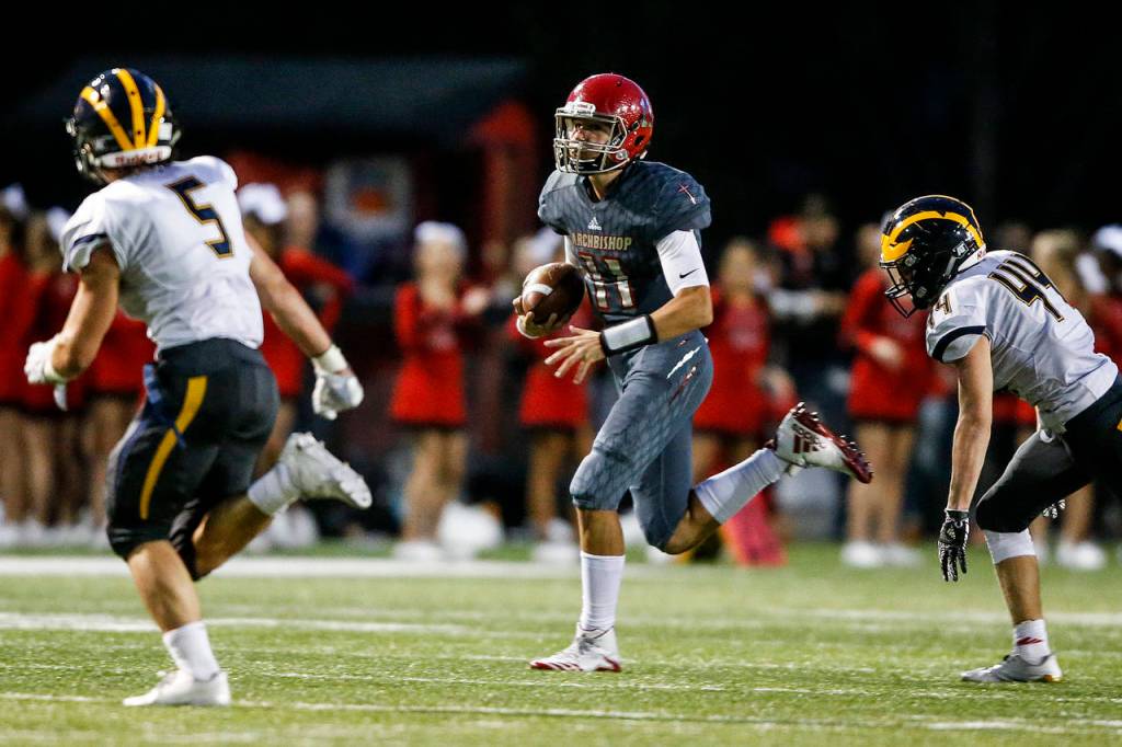 Archbishop Murphy quarterback Victor Gabalis (center) scrambles during a game against Bellevue at Archbishop Murphy High School in Everett on Sept. 22, 2017. (Ian Terry / The Herald)