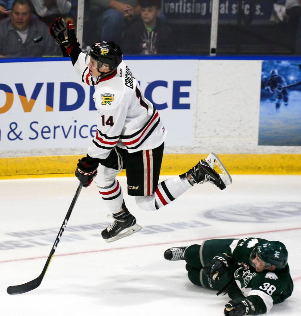 The Winterhawks Jake Gricius jumps to capture the puck over the Silvertips Kevin Davis during a game Sept. 23, 2017, at Xfinity Arena in Everett. (Kevin Clark / The Herald)