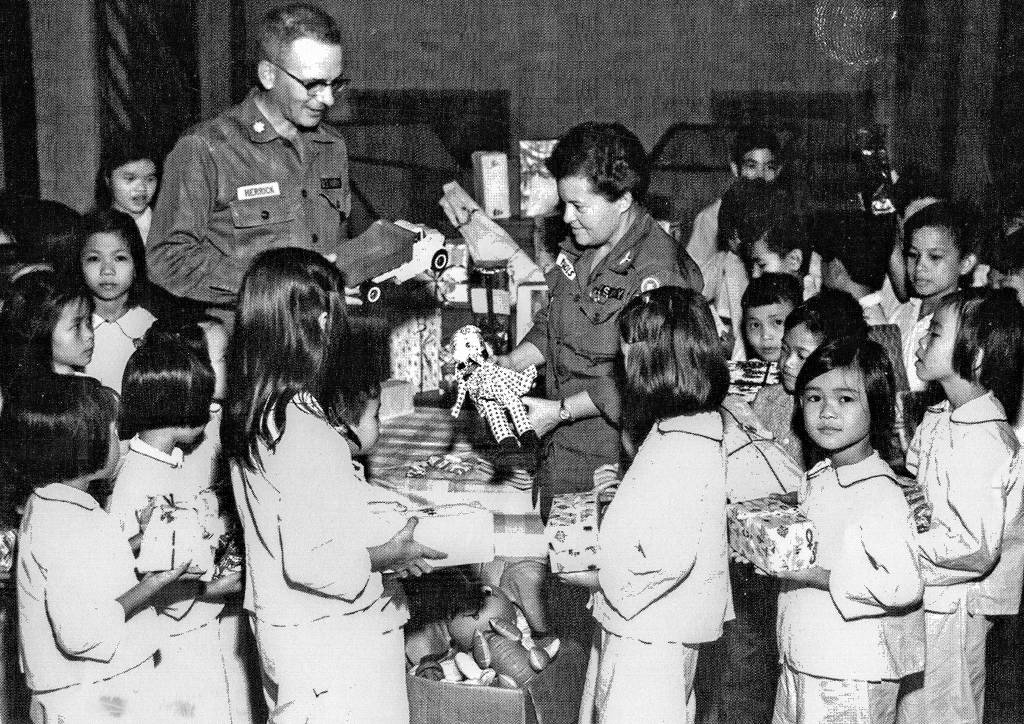 Army nurse Barbara Jean Nichols, who later rose to the rank of lieutenant colonel, and another officer distribute gifts at an orphanage in Saigon in the 1960s during the Vietnam War. (Nichols collection photos)