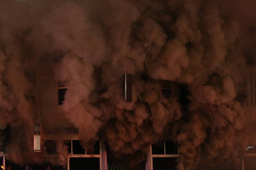 Black smoke rolls out from Everett Office Furniture on Broadway. (Andy Bronson / The Herald)