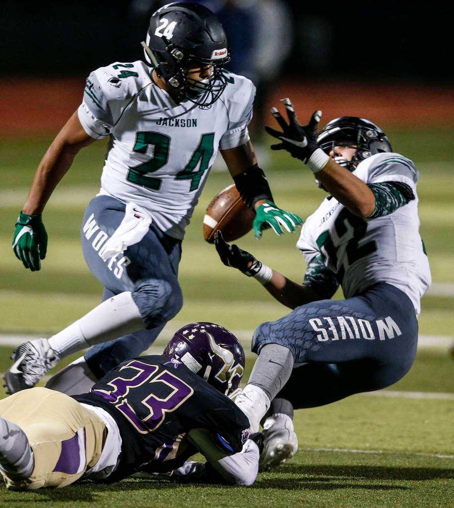 Jacksons Nick Walsh (right) fumbles after being hit by Lake Stevens Junior Robinson (33) during a game Sept. 29, 2017, at Lake Stevens High School. (Ian Terry / The Herald)
