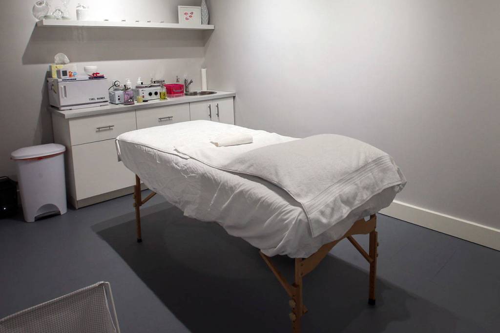 Private treatment rooms have a massage table, towel warmer and mood lighting. (Kevin Clark / The Herald)