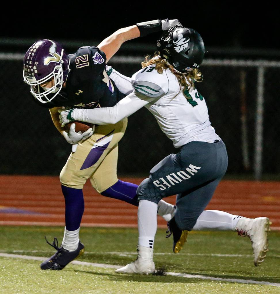 Lake Stevens Austin Murren (left) stiff-arms Jacksons Chris Grayson during a game at Lake Stevens High School on Sept. 29. (Ian Terry / The Herald)