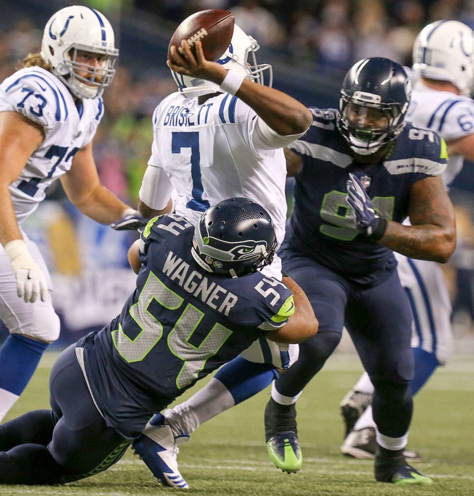 Colts quarterback Jacoby Brissett gets a pass attempt off with Seahawks linebacker Bobby Wagner on his heels and Seahawks defensive lineman Sheldon Richardson closing Sunday night at CenturyLink Field in Seattle on October 1, 2017. Seahawks won 46-18. (Kevin Clark / The Herald)