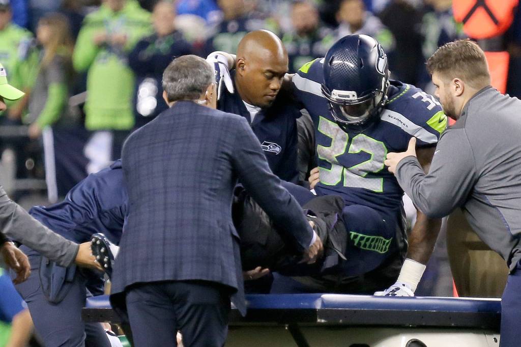Seahawks running back Chris Carson is loaded unto the medical cart Sunday night at CenturyLink Field in Seattle on October 1, 2017. Seahawks won 46-18. (Kevin Clark / The Herald)