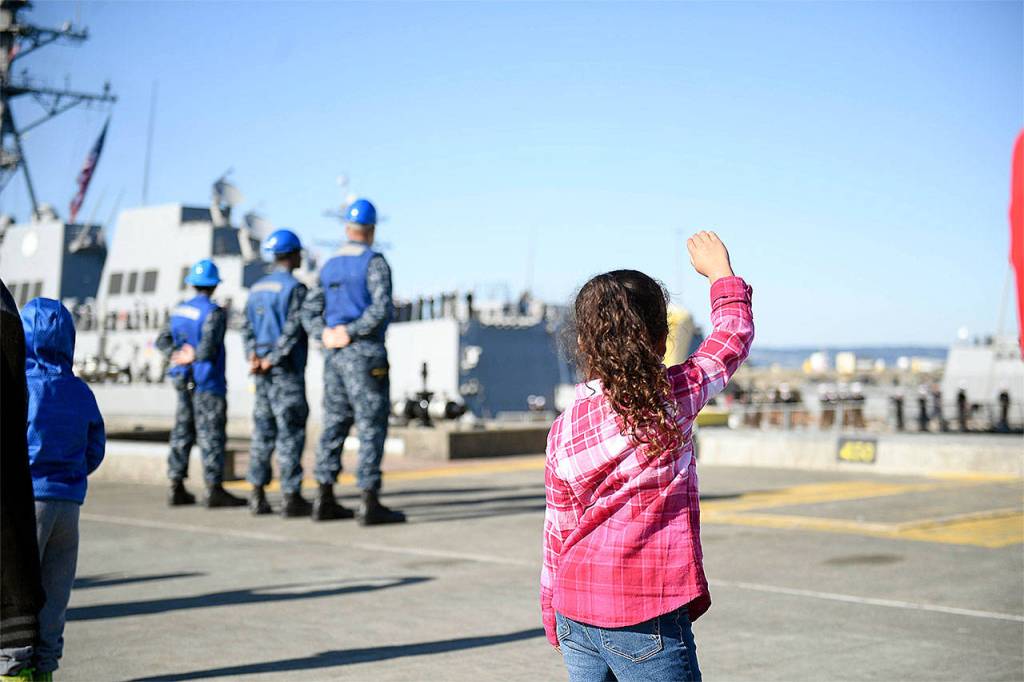 Family members of sailors assigned to the Arleigh Burke class guided-missile destroyer USS Sampson (DDG 102) wave goodbye as they prepare to depart Naval Station Everett for deployment Oct. 3. (U.S. Navy photo by Mass Communication Specialist 2nd Class Joseph Montemarano)