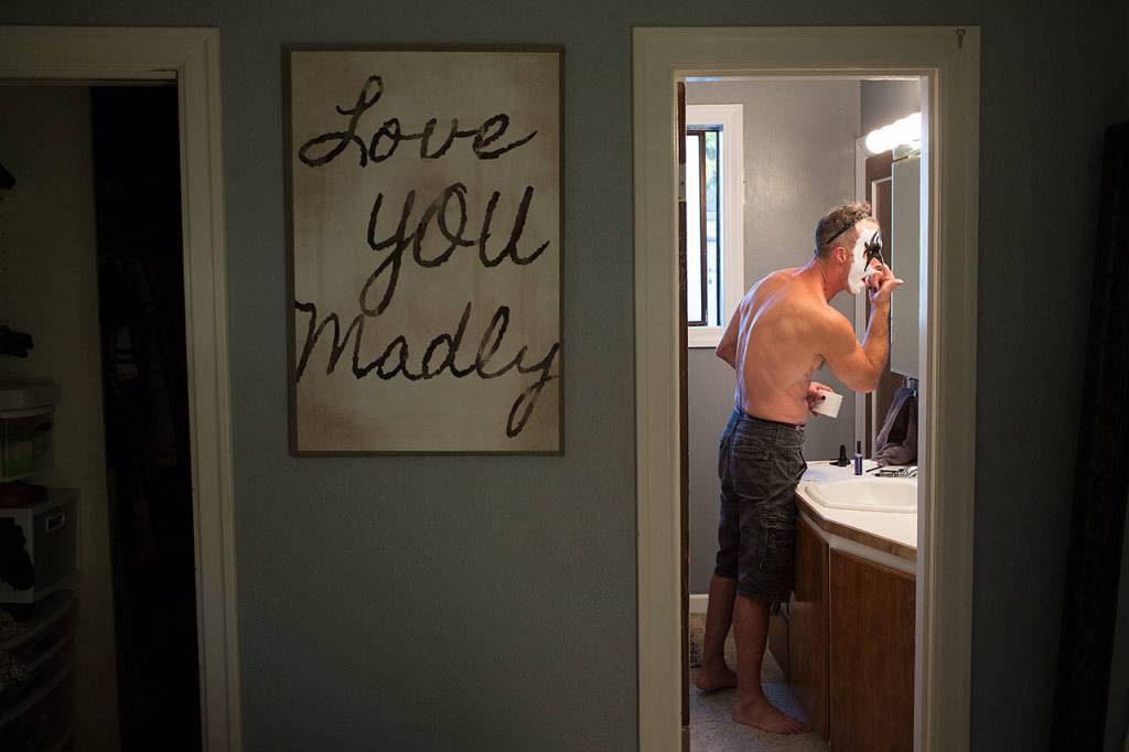 Applying makeup in his bathroom at home, Everett paramedic Jack Murrin gets dressed up as Gene Simmons, of KISS fame, on Oct. 5 in Everett. (Andy Bronson / The Herald)