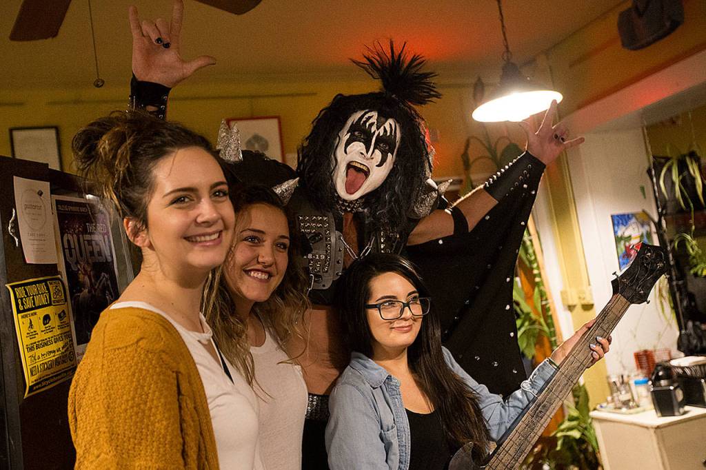 Everett paramedic Jack Murrin, dressed up as Gene Simmons of KISS fame, listens to other poets and speakers at an open mic session at Cafe Zippy on Oct. 5 in Everett. (Andy Bronson / The Herald)