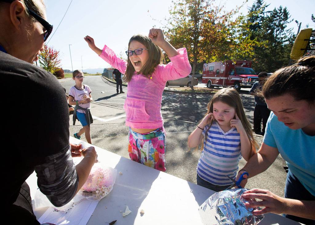 Ruby Carlson plugs her ears as Dutch Hill Elementary third grader Moriah Landry screams in joy after discovering her egg unbroken after surviving a a 70-foot drop from the top of a ladder truck on Thursday, Oct. 5, 2017 in Snohomish, Wa. (Andy Bronson / The Herald)