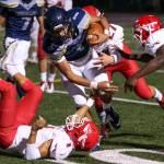 Arlingtons Tallen Williams carries the ball against the Marysville Pilchuck defense during a game Oct. 6, 2017, at Arlington High School. (Kevin Clark / The Herald)