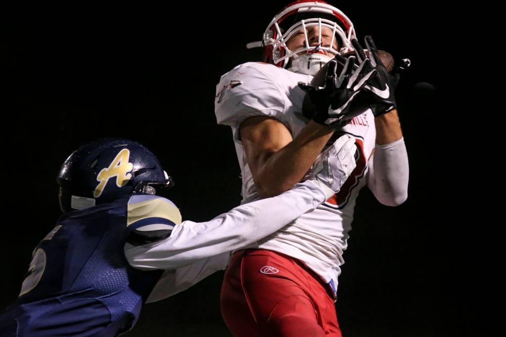 Marysville Pilchucks Justin Trueax makes a reception over Arlingtons Tucker Bovard at Arlington High School on Oct. 6. (Kevin Clark / The Herald)
