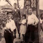 When the fighting stopped a month or so after Gerald Rogers got to the Korean War, he stayed on another year. Here, he was photographed with local children.