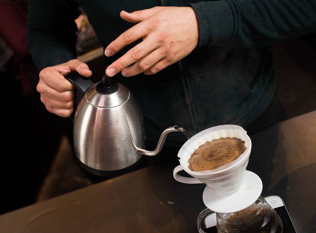 Making circles as he pours, Barista Ryan Bisson brews up one of four coffees from Bean Box and reviews each while at Narrative Coffee on Oct. 3 in Everett. (Andy Bronson / The Herald)