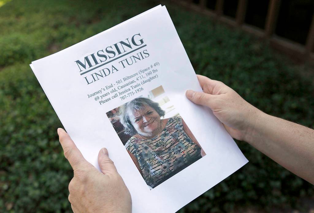 Jessica Tunis stands outside a Red Cross evacuation center and holds a flyer about her missing mother Wednesday in Santa Rosa, California. (AP Photo/Eric Risberg)