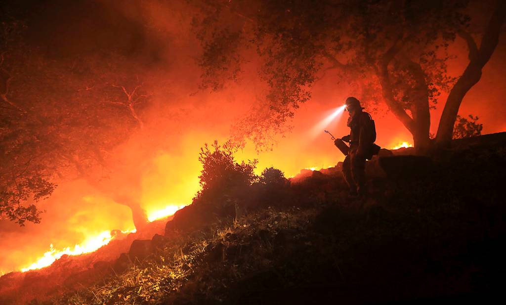 A San Diego Cal Fire firefighter monitors a flare up on a the head of a wildfire (the Southern LNU Complex), off of High Road above the Sonoma Valley on Wednesday in Sonoma, California. (Kent Porter/The Press Democrat via AP)