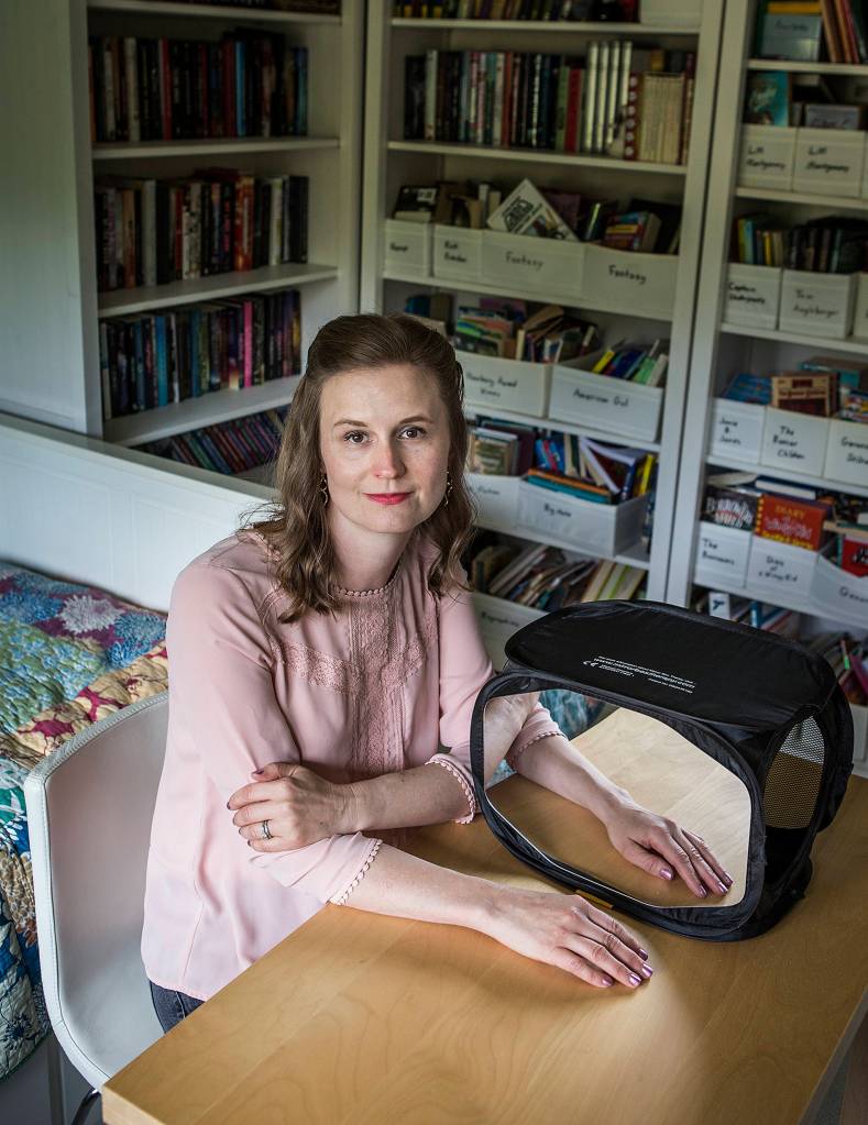 Jennifer Bardsley, of Edmonds, uses a mirror box to help combat Complex Regional Pain Syndrome, a condition where symptoms and pain from an injury can persist long after physical healing is complete. (Ian Terry / The Herald)