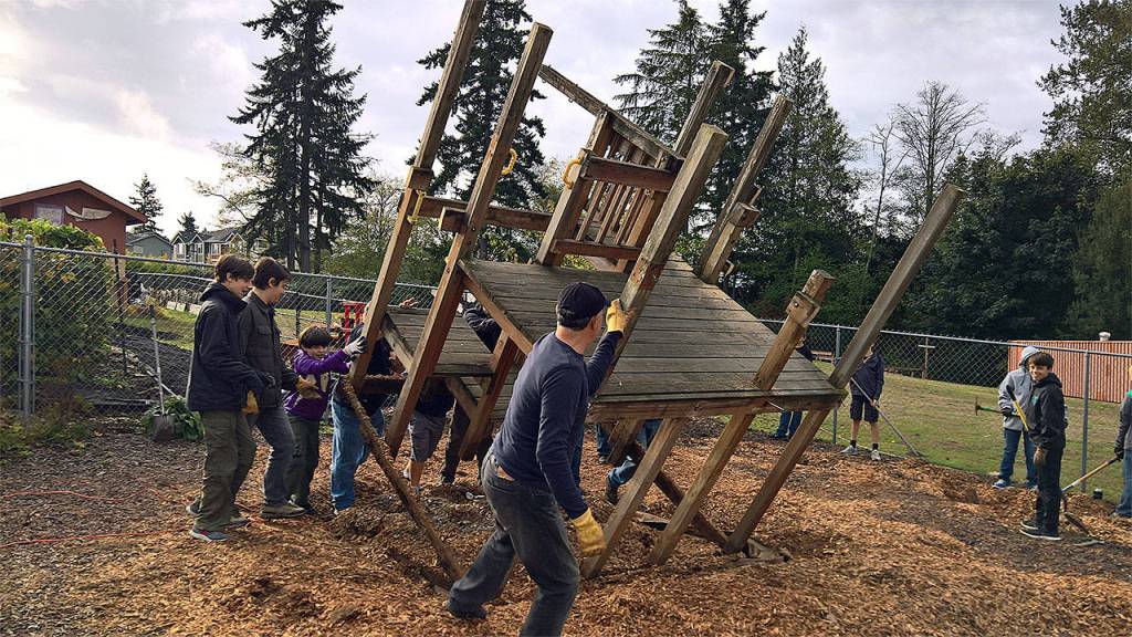 Boy Scouts Troop 120 of Everett remove an outdated play structure and redistribute the bark to other landscaping areas at Advent Lutheran Church. (Contributed photo)