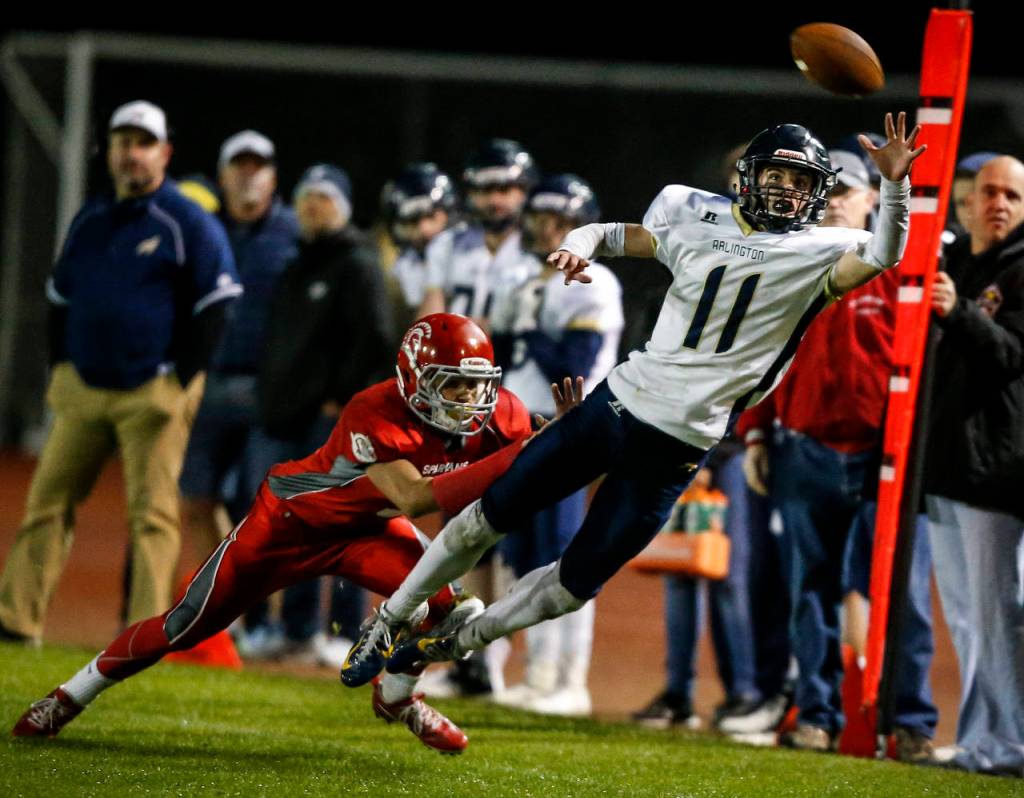 Arlingtons Campbell Hudson (11) tries for a one-handed catch during the annual Stilly Cup game against Stanwood at Stanwood High School on Oct. 13, 2017. (Ian Terry / The Herald)