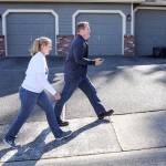 Mariah Low (left), along with Sam Low go door-to-door Sunday afternoon in unincorporated Everett. (Kevin Clark / The Herald)