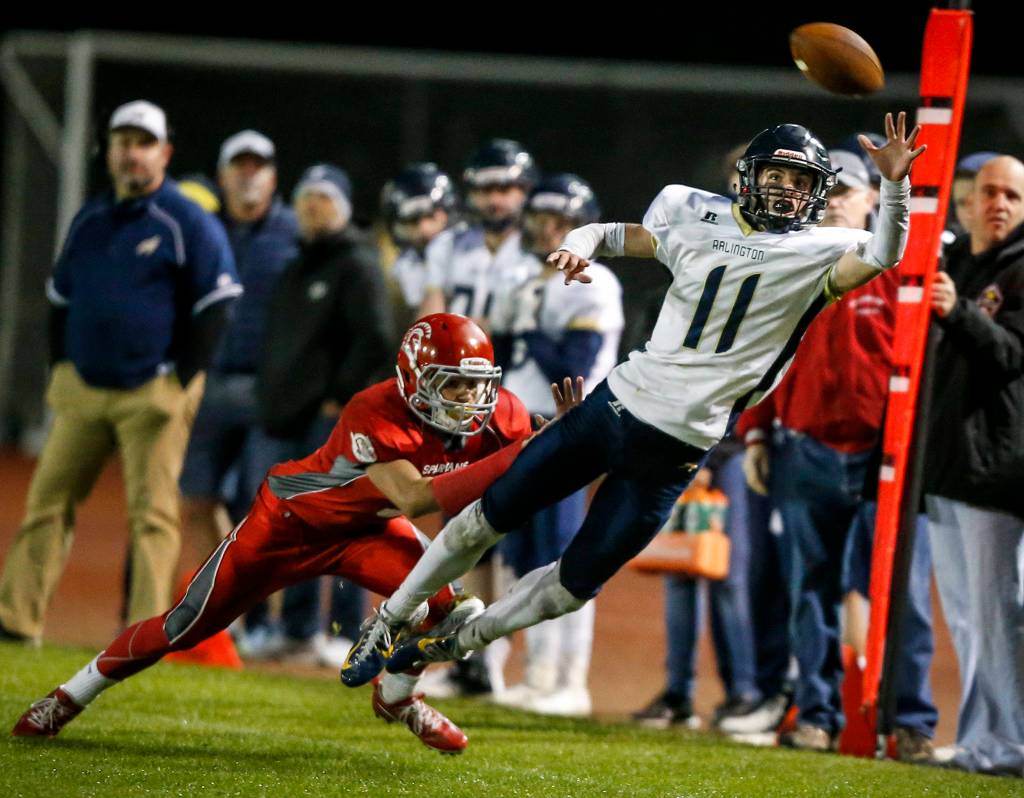 Arlingtons Campbell Hudson (11) tries for a one-handed catch during the annual Stilly Cup game against Stanwood at Stanwood High School on Oct. 13. (Ian Terry / The Herald)