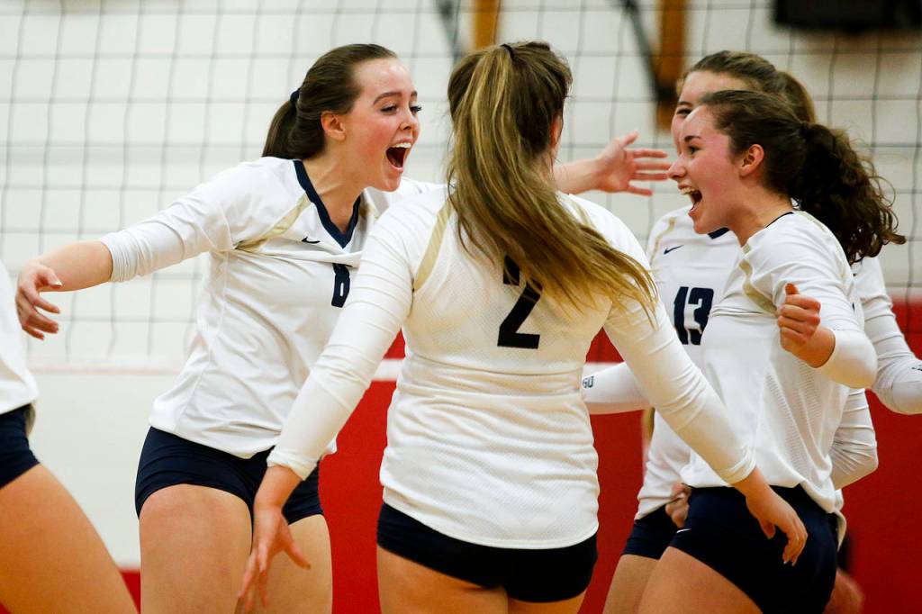 Arlingtons Reese Talbot (left) celebrates a point Tuesday during the Eagles match against Stanwood at Stanwood High School (Ian Terry / The Herald)