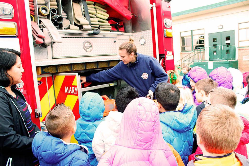 Marysville firefighter Kaitlan Hereth shows local students some of the tools in a fire engine. (Contributed photo)