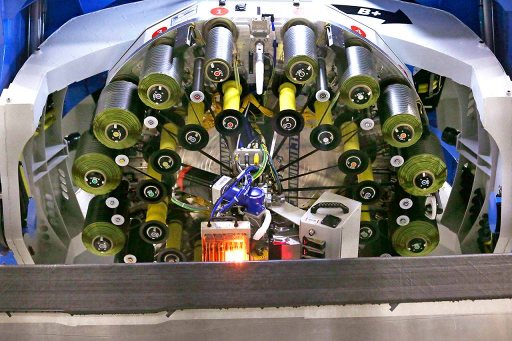 An automated fiber placement machine lays down carbon fiber strips to create a massive wing for the Boeing 777X on Monday in Everett. (AP Photo/Elaine Thompson)