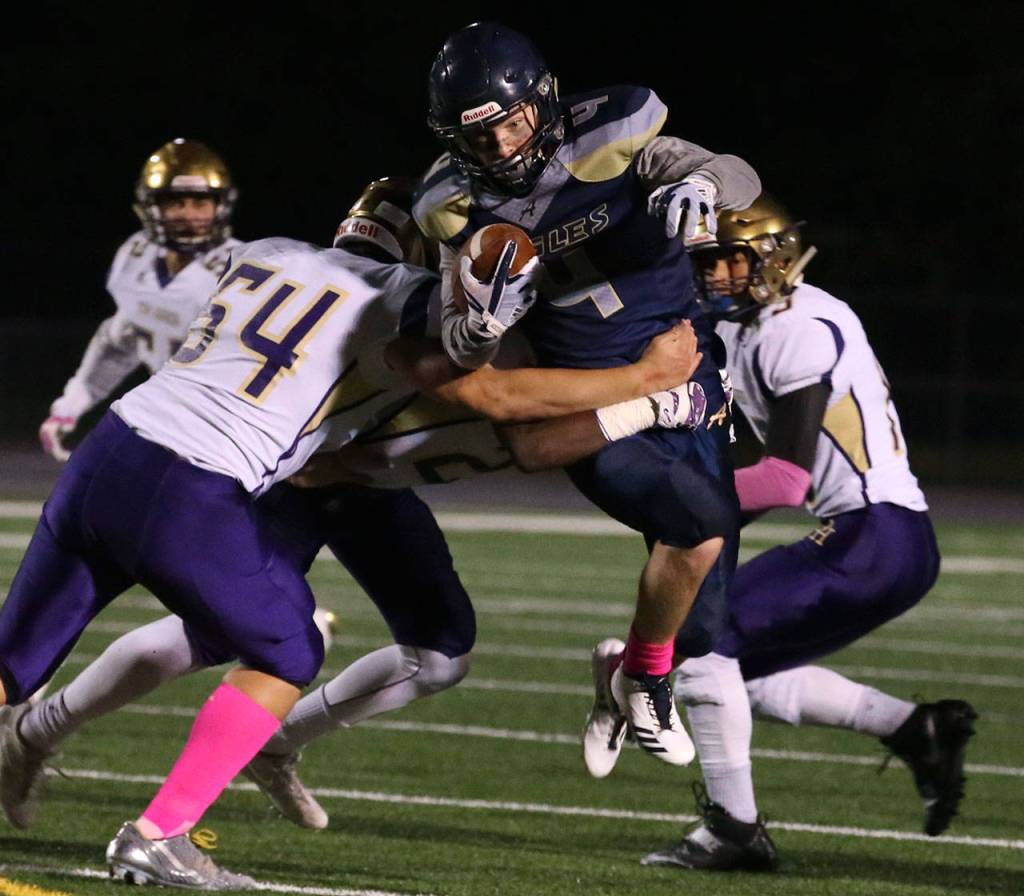 Arlingtons Jacob Hubbard is wrapped up by Oak Harbor defenders during a game oct. 20, 2017, at Arlington High School. (Kevin Clark / The Herald)