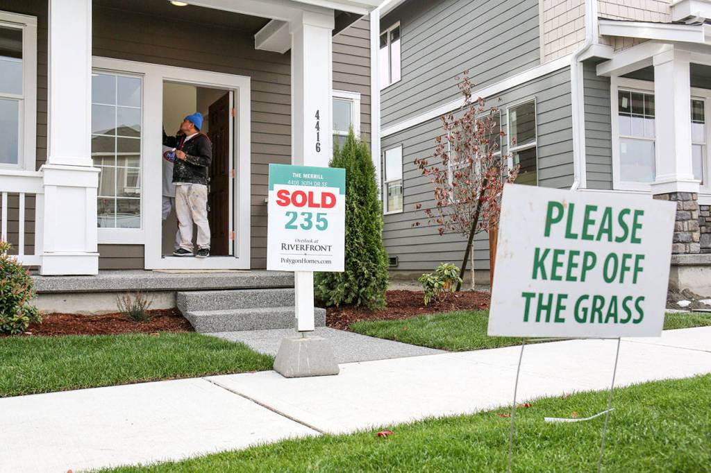 A painter puts the finishing touches on houses at Overlook at Riverfront in Everett on October 25, 2017. (Kevin Clark / The Herald)
