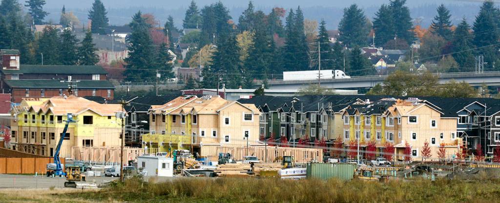 Under construction, The Towns at Riverfront sits in the shadow of Highway 2. (Kevin Clark / The Herald)