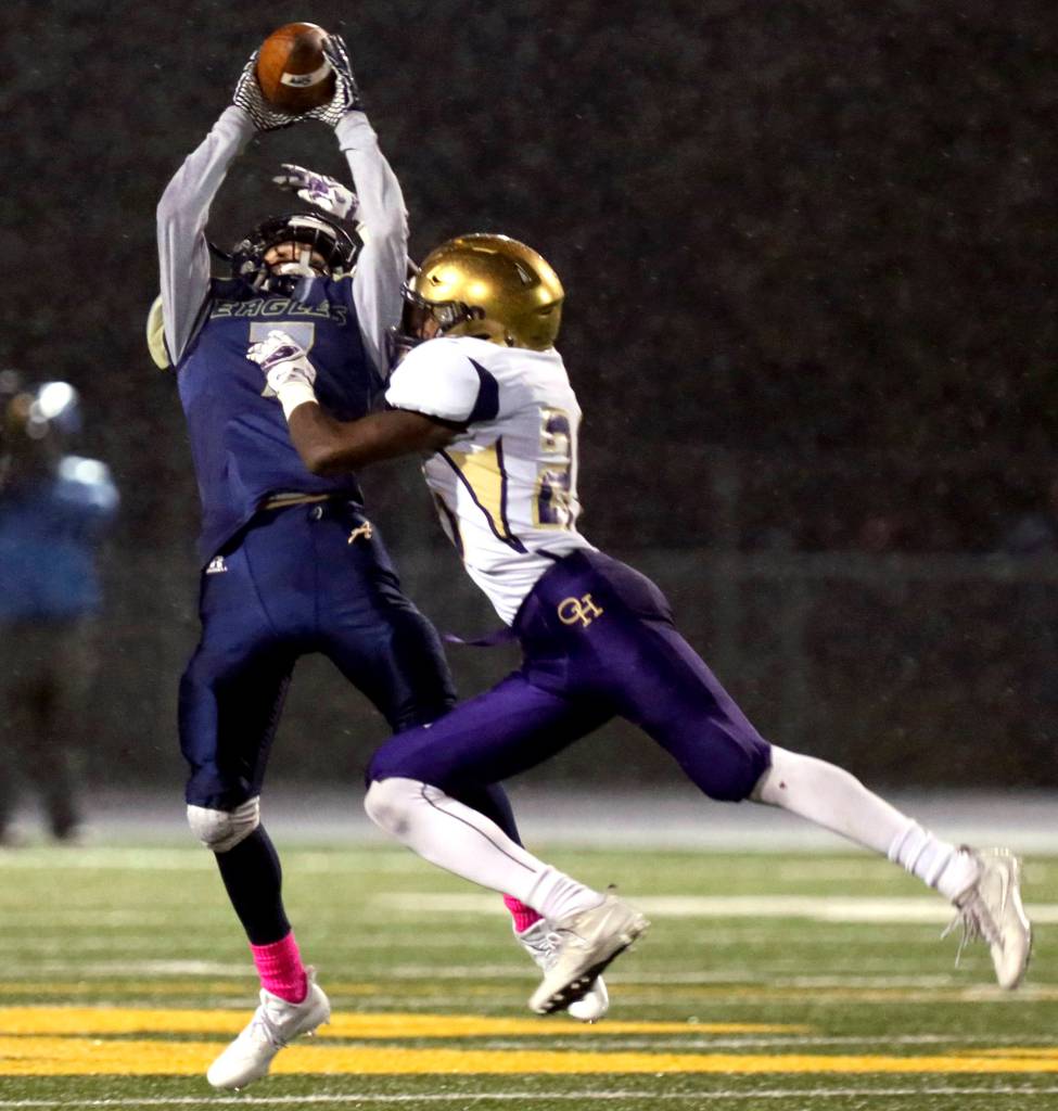 Arlingtons Cooper Cummings makes the catch with Oak Harbors Tamarik Hollins-Passmore defending at Arlington High in Arlington on Oct. 20. (Kevin Clark / The Herald)