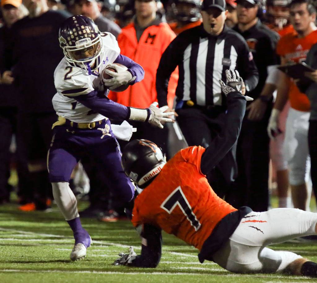 Lake Stevens Keyshawn Mounarath carries the ball with Monroes Efton Chism III attempting a tackle during a game Oct. 27, 2017, at Monroe High School. (Kevin Clark / The Herald)