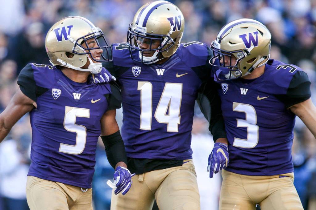 Washingtons Myles Bryant (left) celebrates a fumble recovery with teammatess JoJo McIntosh (center) and Elijah Molden on Oct. 28, 2017, at Husky Stadium. Washington won 44-23. (Kevin Clark / The Herald)