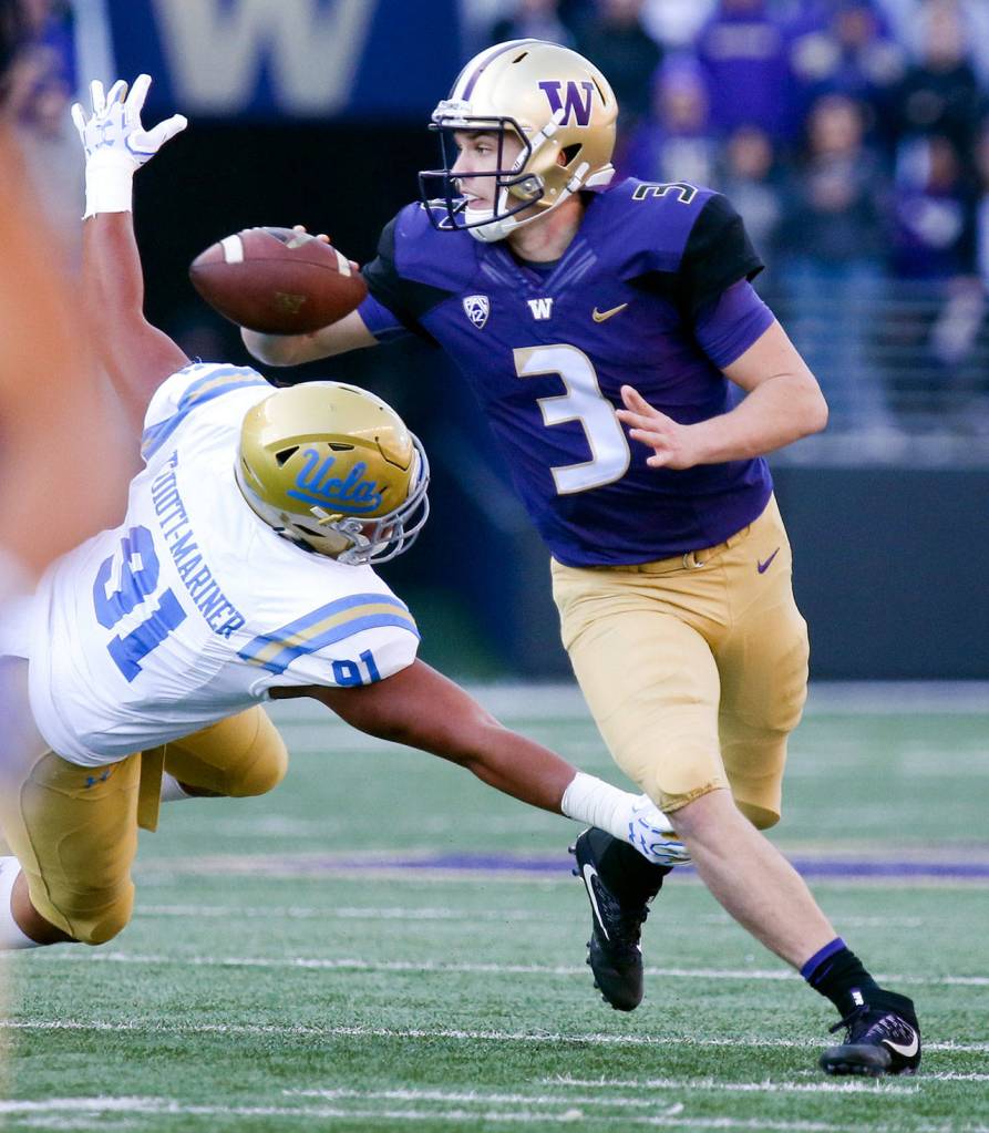 Washingtons Jake Browning makes a shovel pass with UCLAs Will McClure closing on Oct. 28, 2017,Husky Stadium. Washington won 44-23. (Kevin Clark / The Herald)
