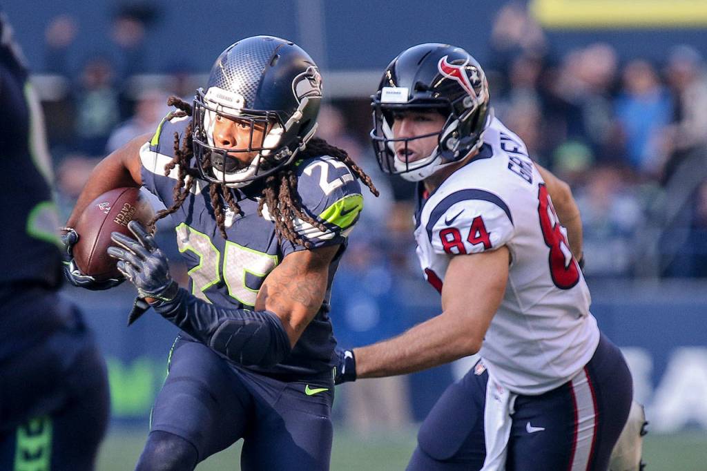 Seahawks corner back Richard Sherman returns a interception with Texans Ryan Griffin trailing Sunday afternoon at CenturyLink Field on October 29, 2017`.(Kevin Clark / The Herald)