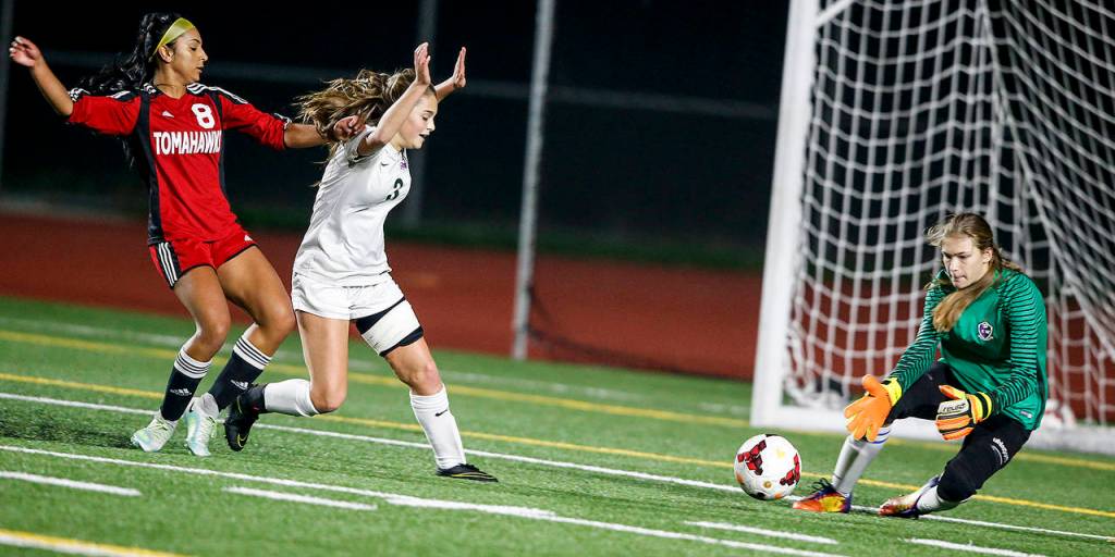 Edmonds-Woodway goalkeeper Hannah Hicks (right) saves a shot by Marysville Pilchucks Trina Davis (left) as the Warriors Juliet Hufford (center left) defends during a 3A District 1 semifinal match Tuesday at Edmonds Stadium. (Ian Terry / The Herald)