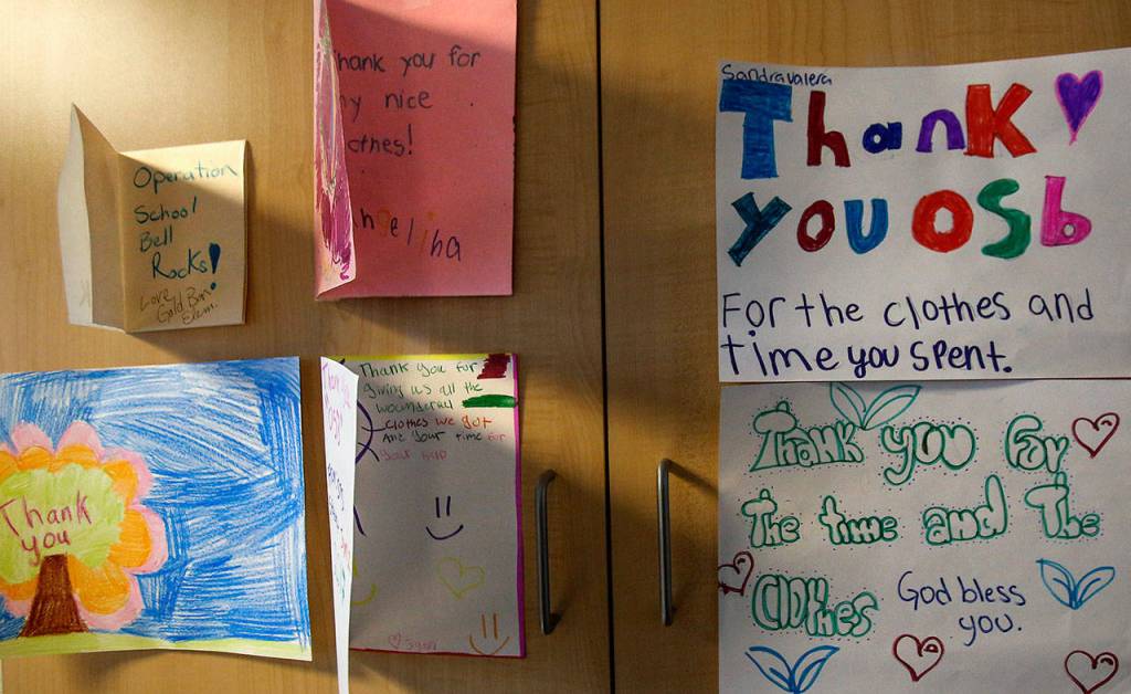 Handmade thank-you notes from children hang on cabinet doors in an office of the Assistance League of Everett. (Dan Bates / The Herald)