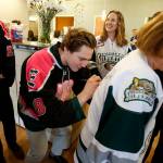 Silvertips left wing Brandson Hein (center) signs the back of a jersey for Providence Hospital RN Marcia Boffey during a team visit on Nov. 1, 2017. (Ian Terry / The Herald)