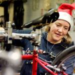 Sarah Molitch looks over bicycle under repair at Sharing Wheels in Everett on Nov. 5. (Kevin Clark / The Herald)