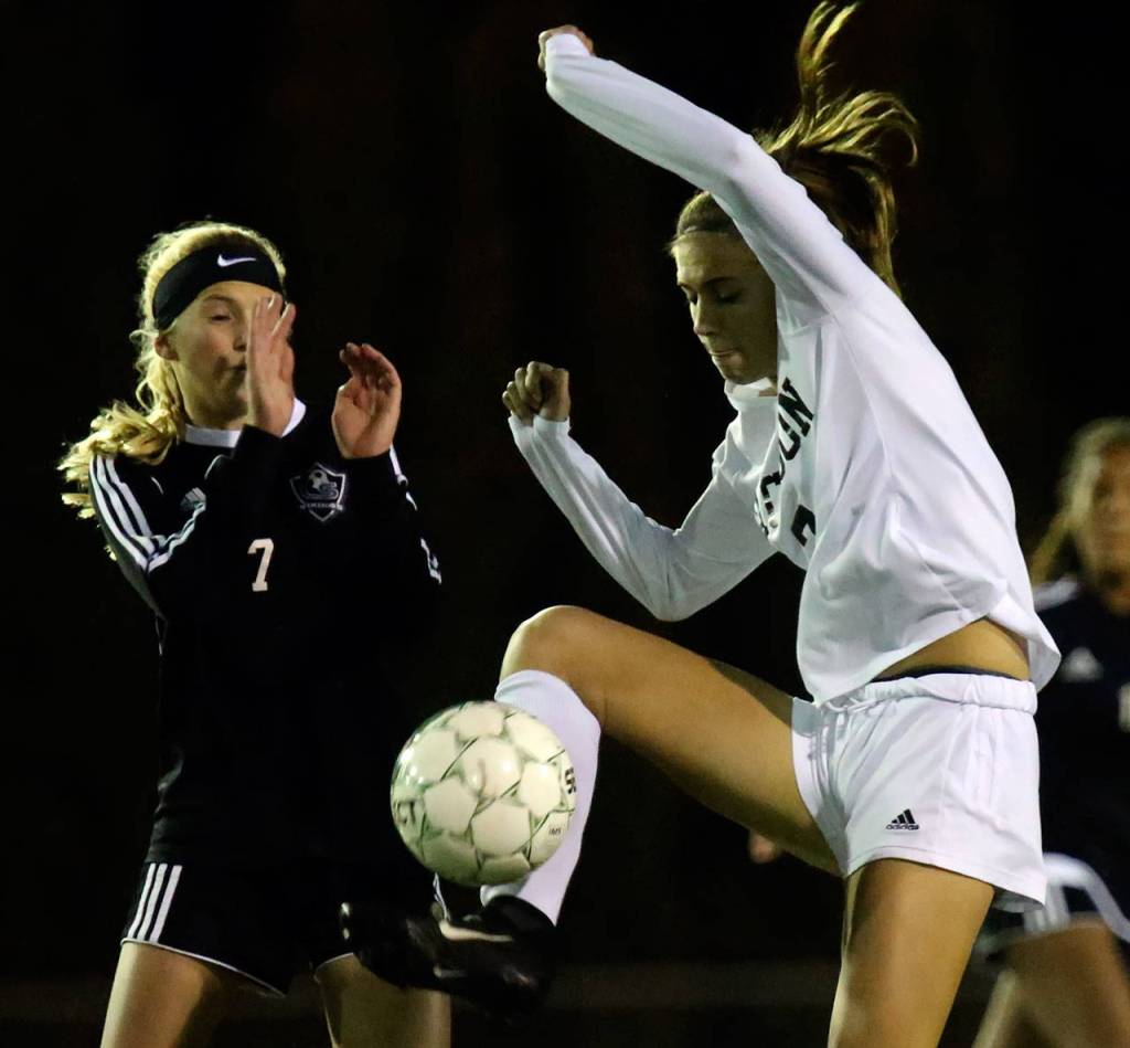 Jacksons Keile Hansen jumps for a loose ball with Lake Stevens Callaway Knutson defending during a playoff game on Nov. 2, 2017, at Goddard Stadium in Everett. (Kevin Clark / The Herald)