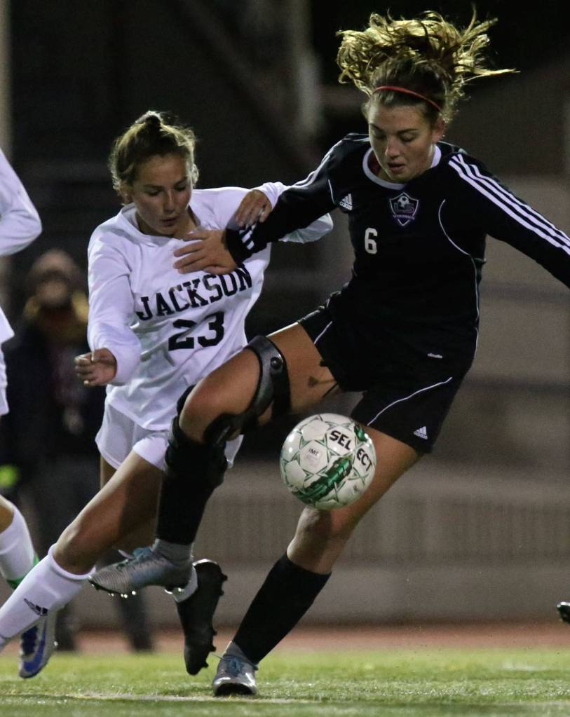 Lake Stevens Sam Foley works to control the ball with Jacksons Gabi Franco closing during a playoff game Nov. 2, 2017, at Goddard Stadium in Everett. (Kevin Clark / The Herald)
